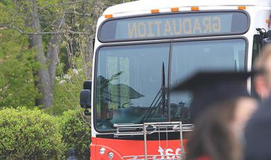 一辆BSU公交大巴上挂着一个毕业标志.